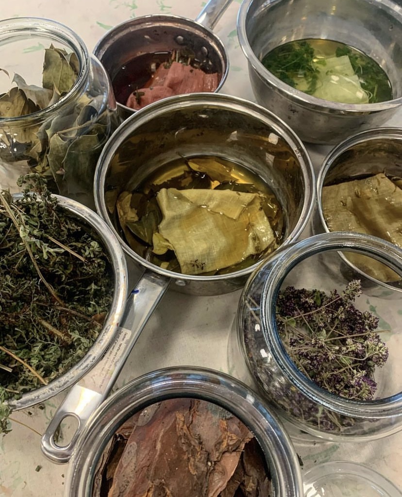 Fabric being boiled in a saucepan with leaves to create a natural dye