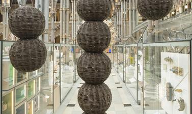 Willow sculpture showing multiple spheres joined vertically and suspended in gallery space